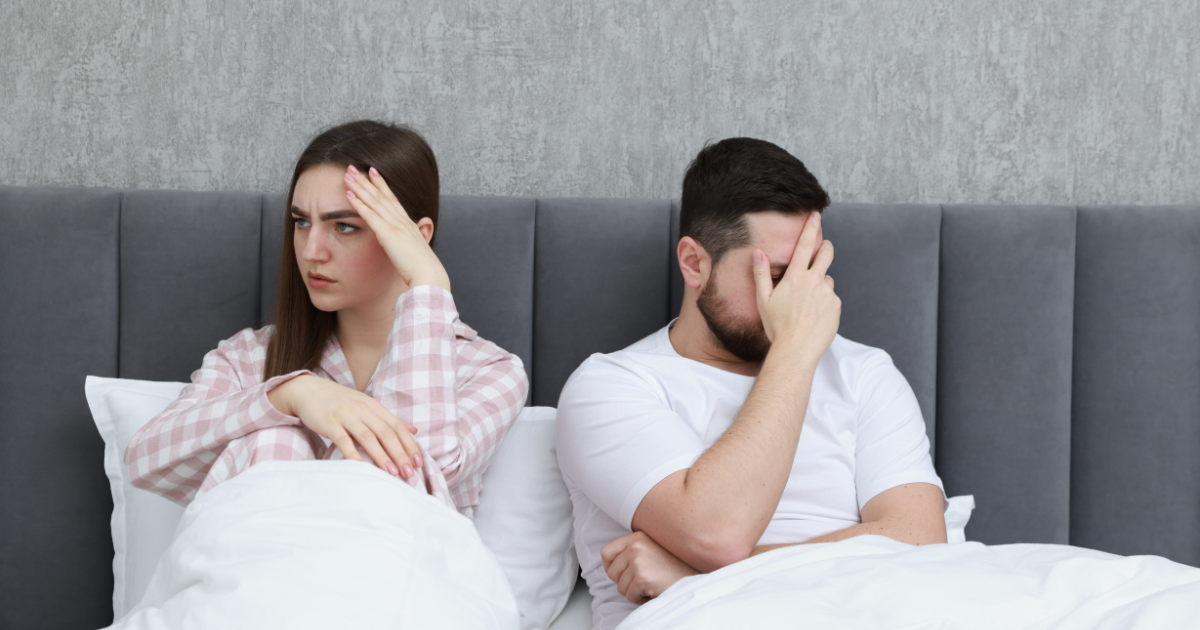 Scham im Schlafzimmer: Paar sitzt angespannt im Bett · Rückzug, Unsicherheit und Druck nach einem intimen Moment